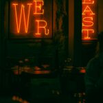 Neon sign glowing warmly in a Paris bar, creating a cozy evening ambiance.