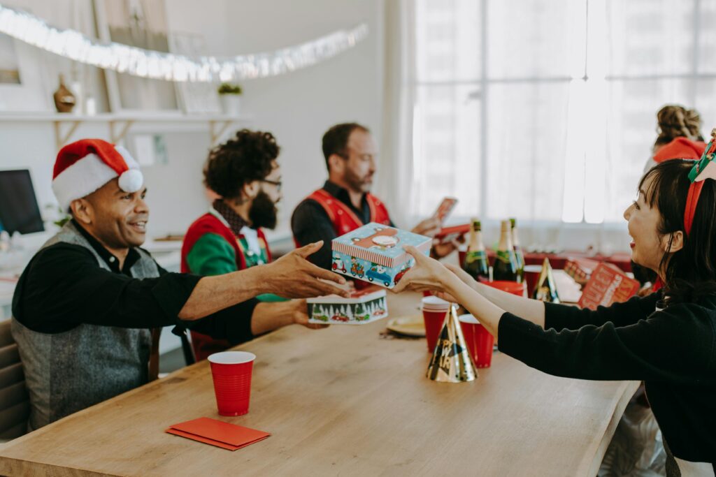 Group of coworkers exchanging gifts at an office Christmas party, spreading joy and holiday cheer.